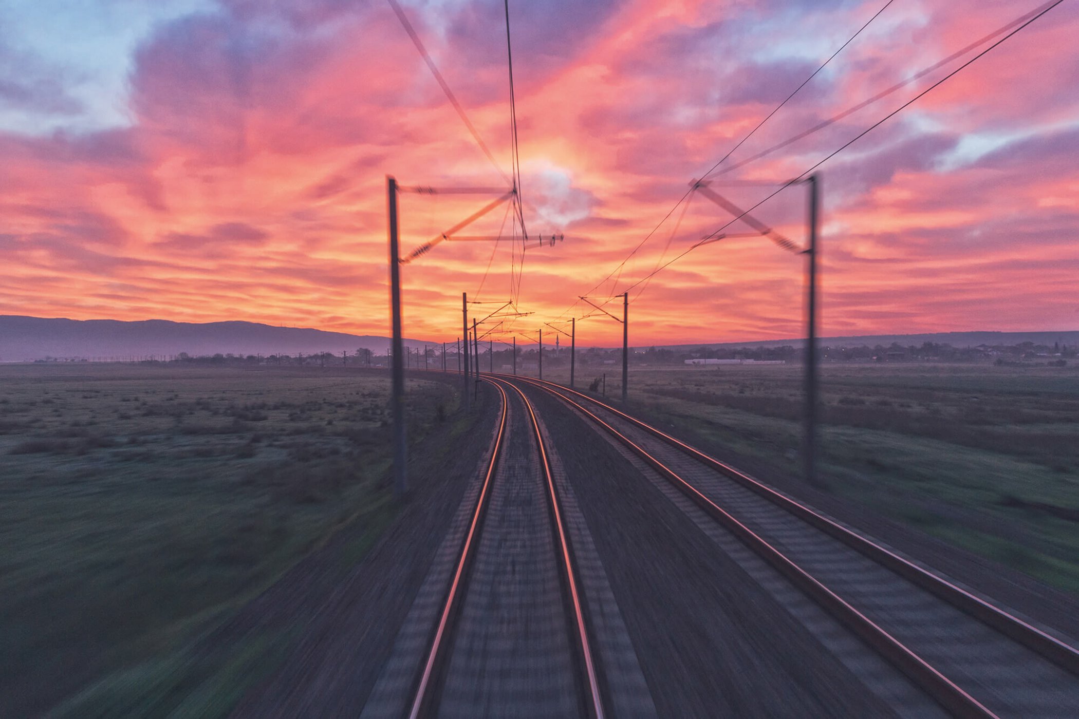 Rails in front of a red-yellow-pink sunset