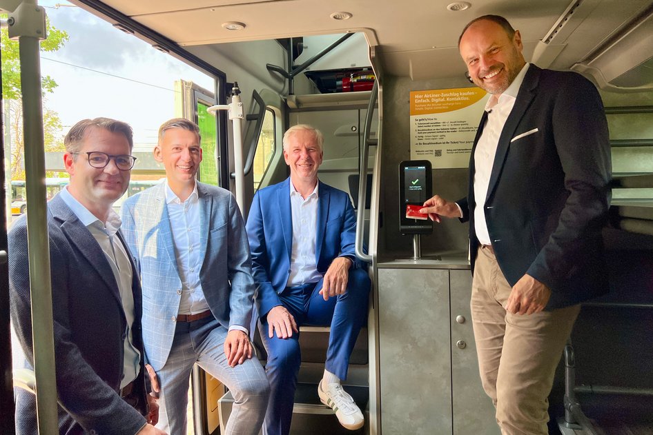 Bastian Dittbrenner (IVU AG), Thomas Kern, Jörg Puzicha, and Arne Rath (Managing Director of HEAG mobilo GmbH) in the AirLiner in front of the new IVU.validator.
