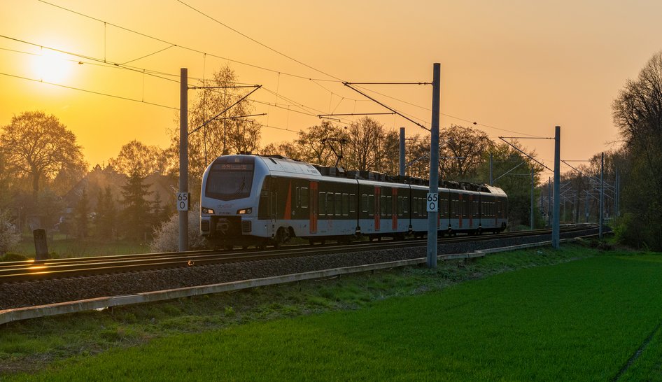 Train on rails in front of a sunset