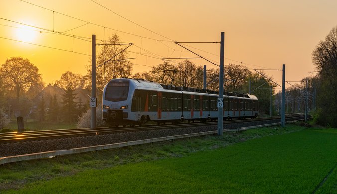 Train on rails in front of a sunset