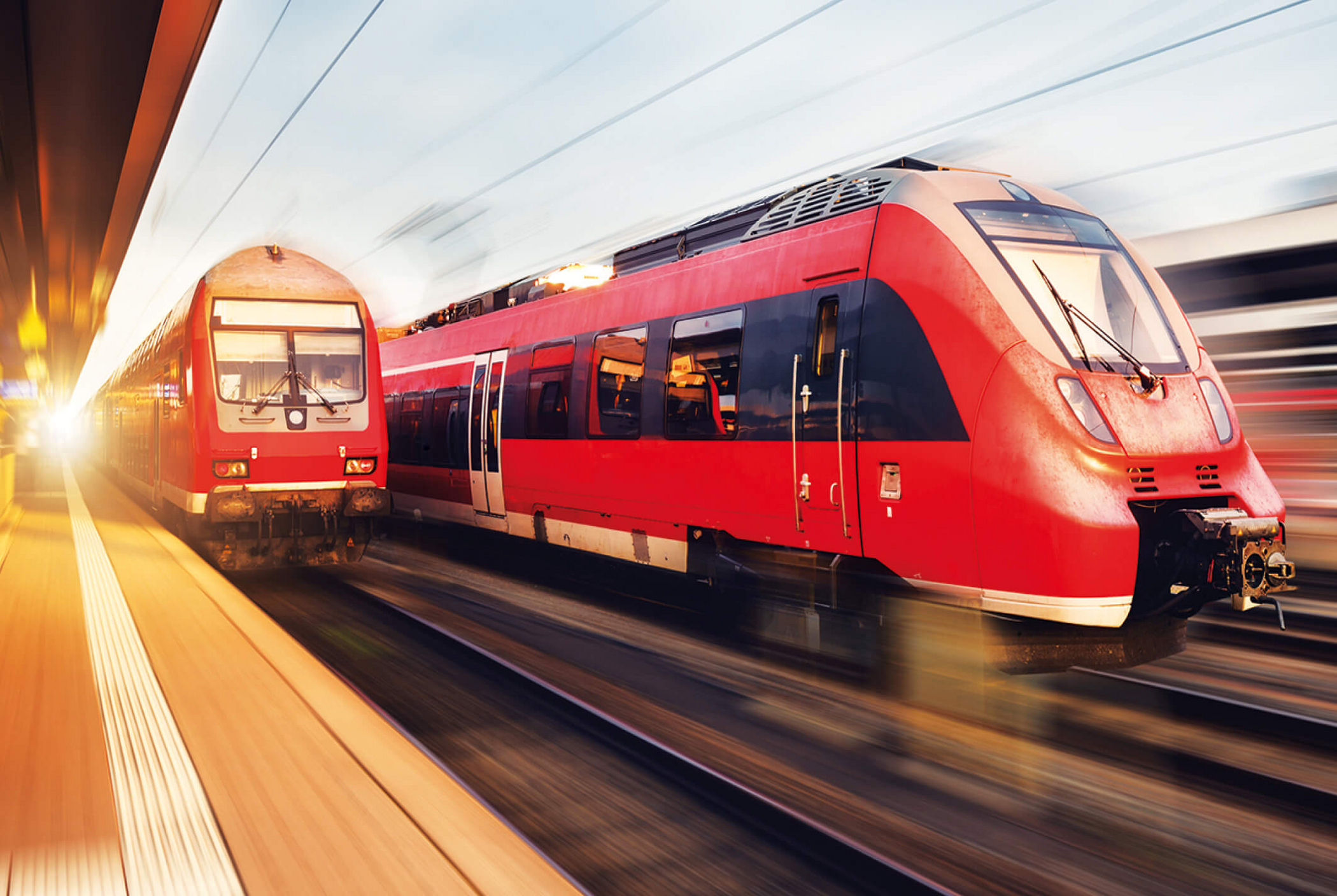 Regionalzüge der Deutschen Bahn fahren am Bahnhof vorbei