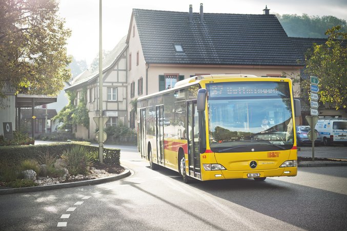 Yellow BLT bus driving through a town