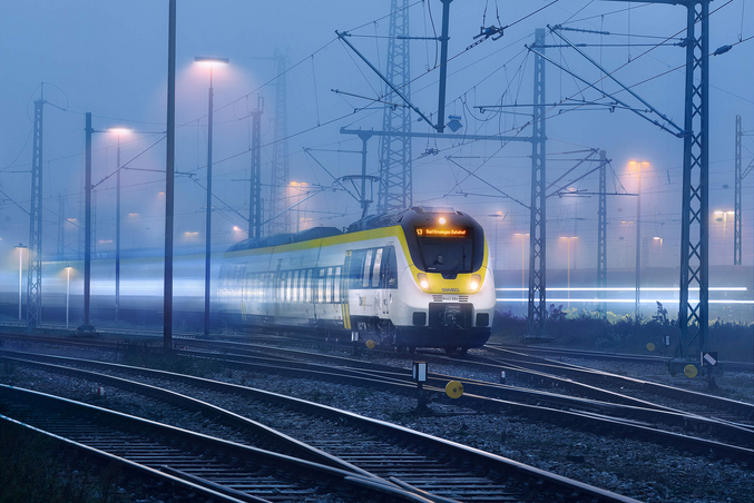 SWEG's yellow and white train runs at night.
