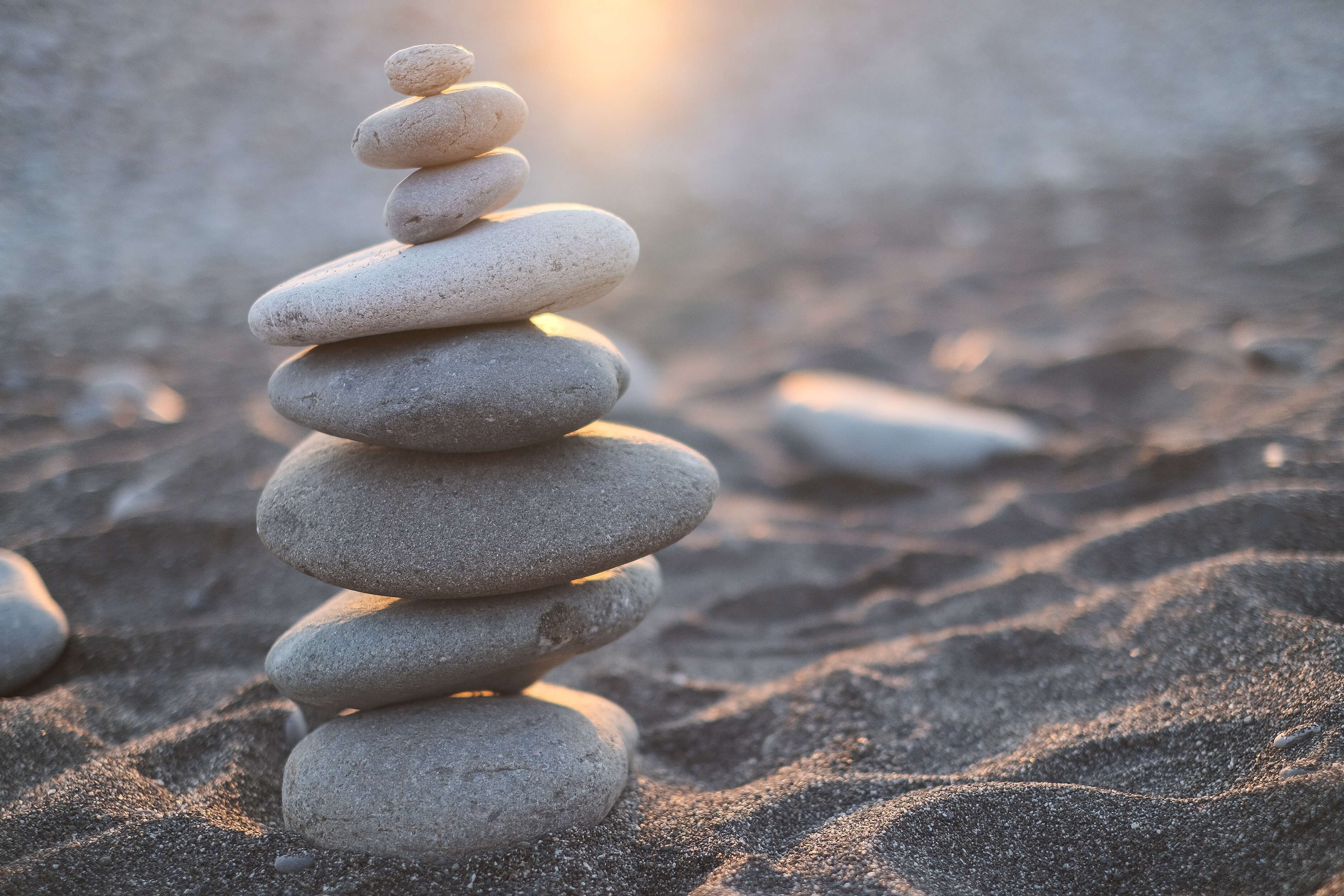 Stacked stones of different sizes on the sand in perfect balance