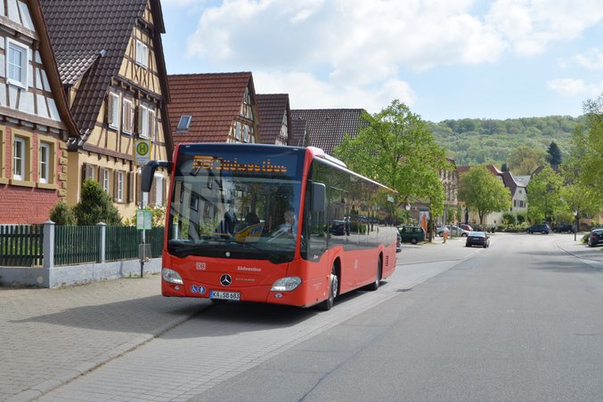 A bus operated by RVS Regionalbusverkehr Südwest GmbH, a subsidiary of DB Regio Straße, is parked at a bus stop.