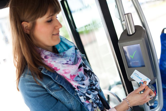 Passenger holds the PlusCard Münster up to the ticket validator