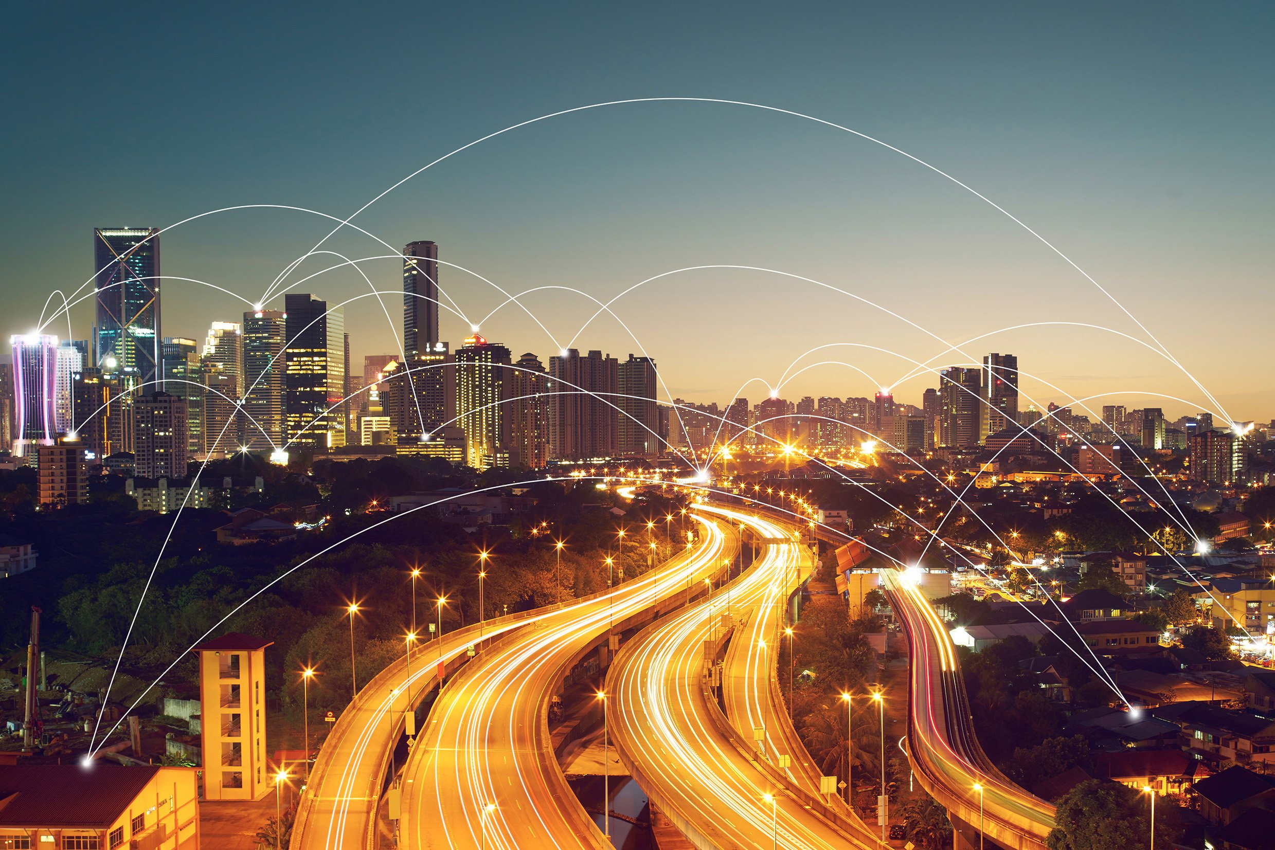 Skyline notturno con autostrade illuminate e nodi connessi come simbolo di mobilità digitale