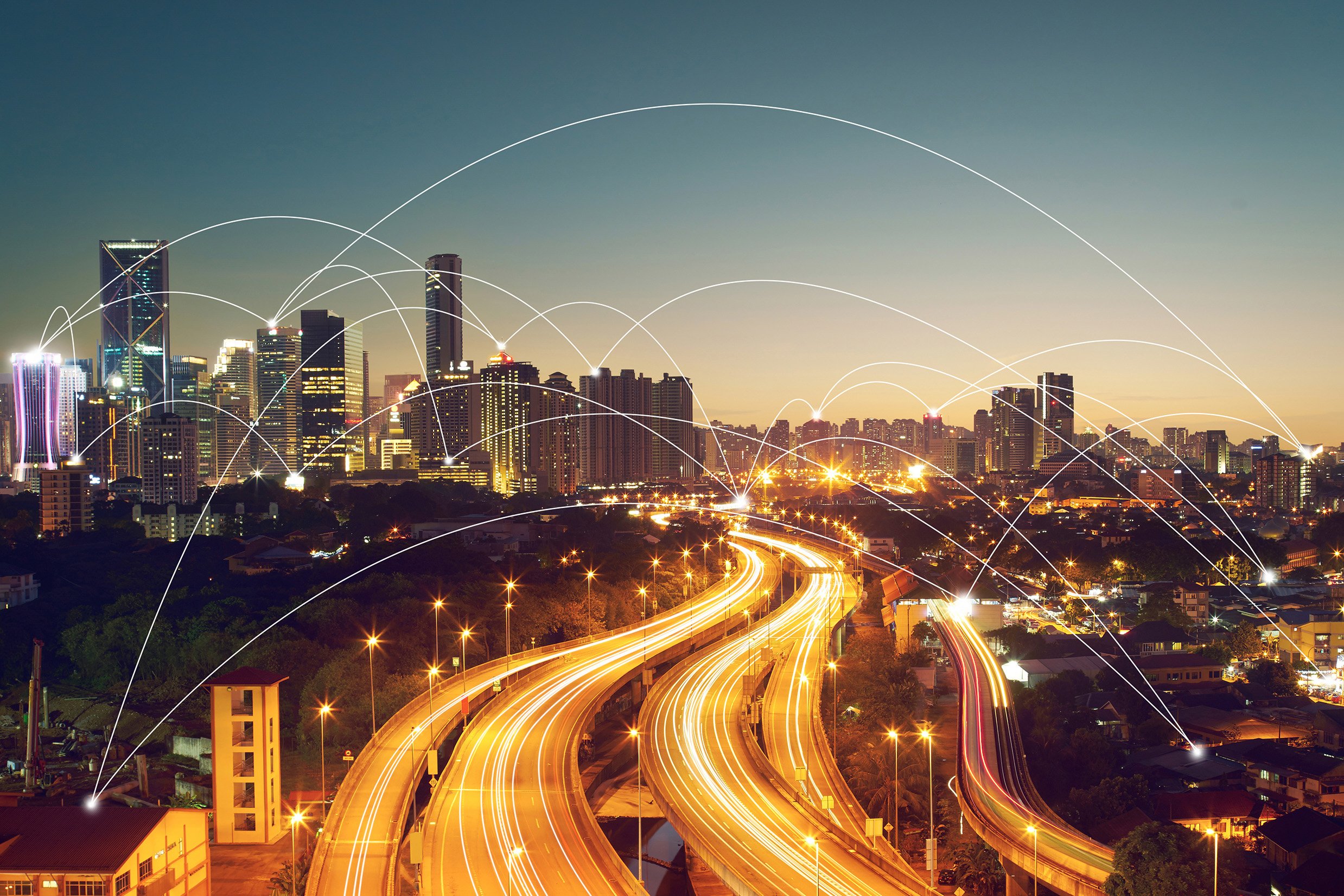 Horizonte urbano nocturno con autopistas iluminadas y nodos conectados como símbolo de movilidad digital