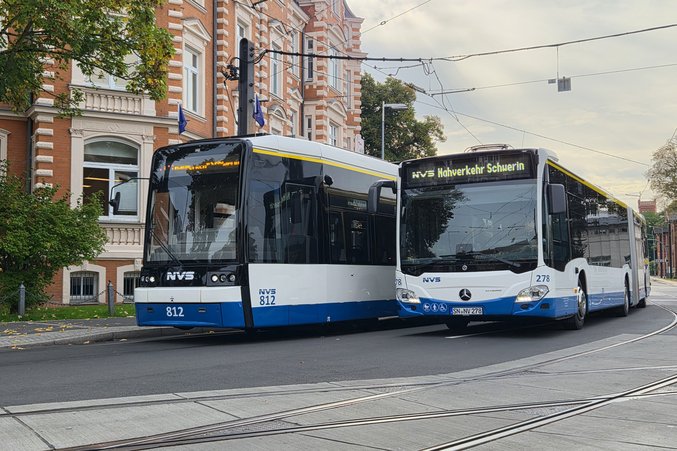 Two buses of the Nahverkehr Schwerin GmbH are driving along a road