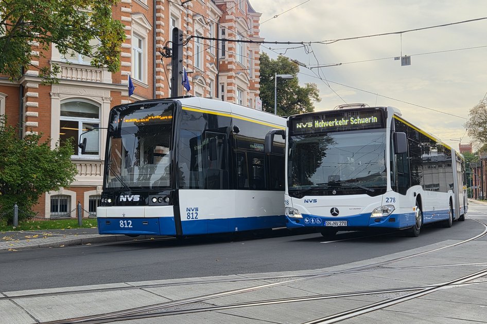 Two buses of the Nahverkehr Schwerin GmbH are driving along a road
