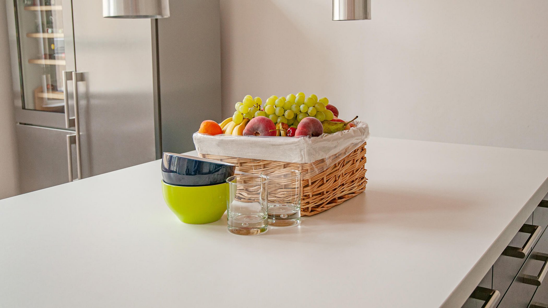 Fruit basket with bowls and glasses on a kitchen table
