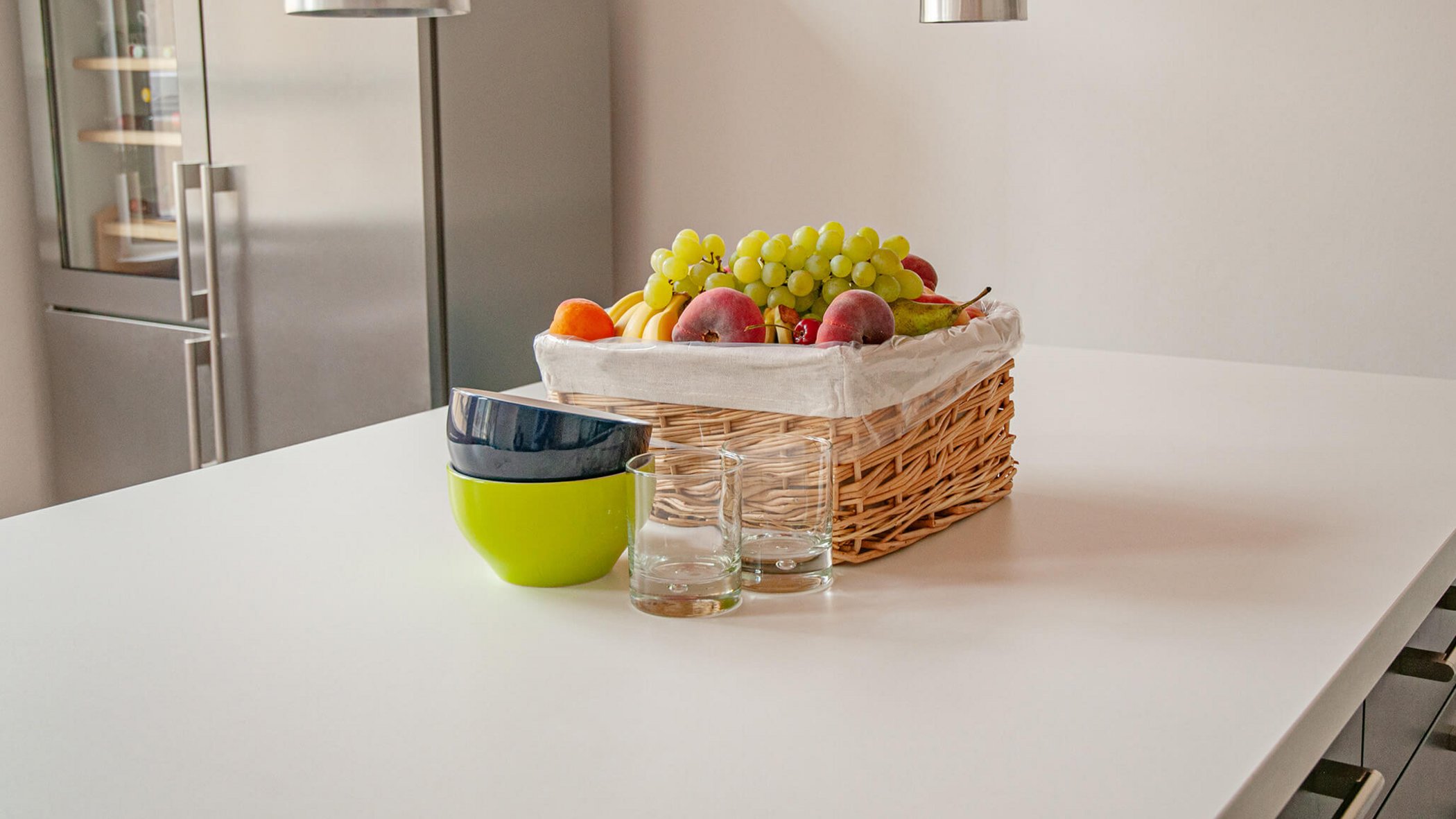 Fruit basket with bowls and glasses on a kitchen table
