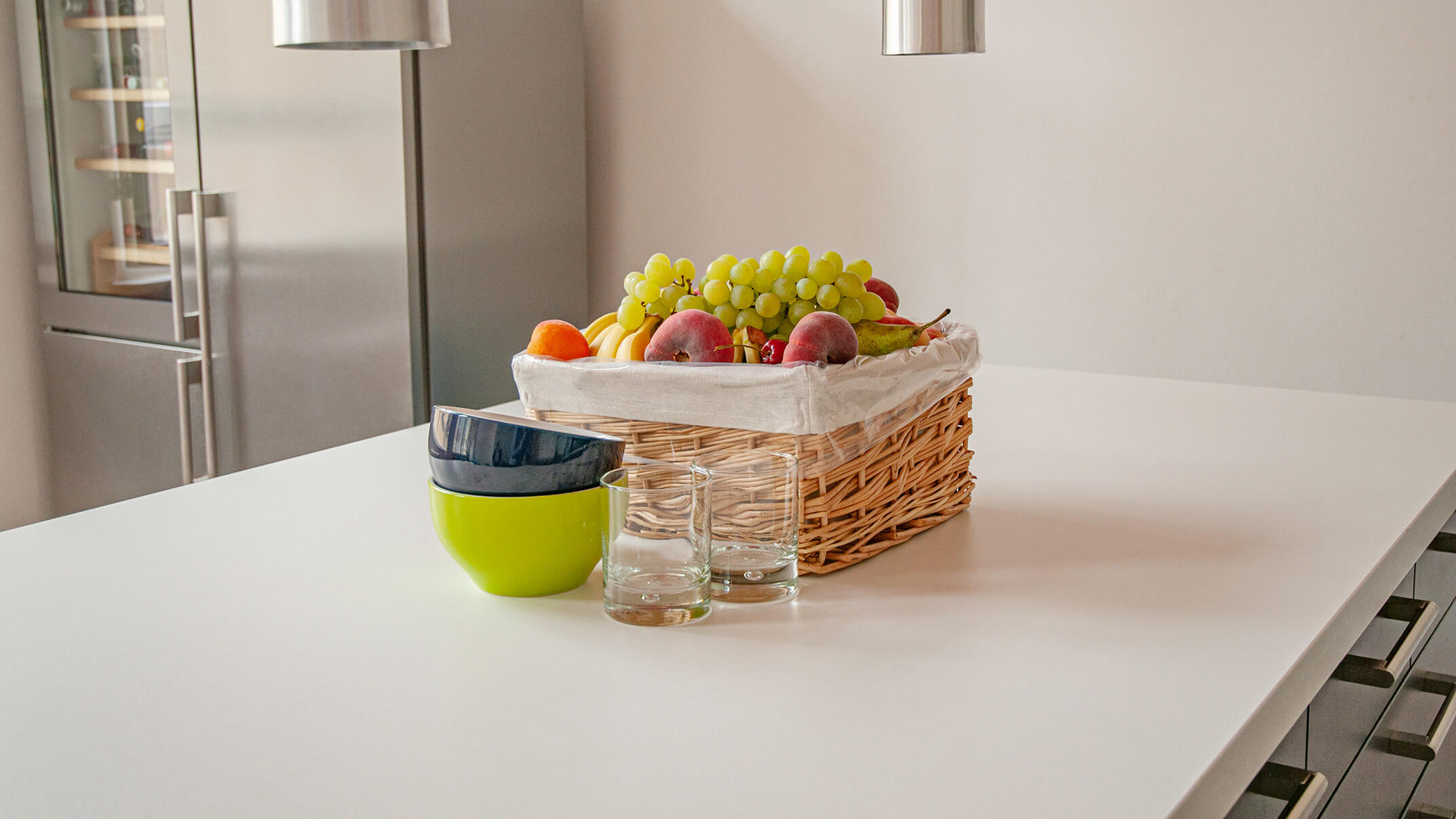 Fruit basket with bowls and glasses on a kitchen table
