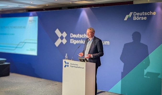 CEO Martin Müller-Elschner hält Vortrag am Rednerpult vor blauer Bühnenkulisse mit Deutsche Börse Logo
