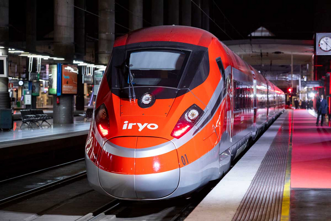 A photo of a red and silver iryo train from the front, standing at the station track.