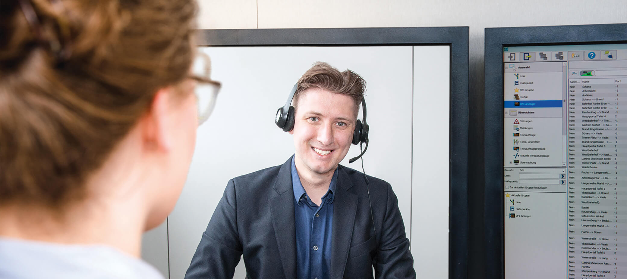 Customer service employee with headset on the phone smiling into the camera