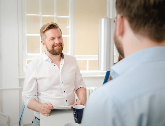 Man from the front talking to a man seen from diagonally behind