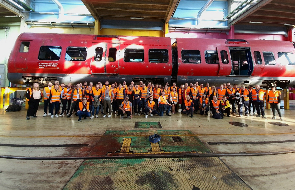 DSB employees in front of a railway wagon in the workshop.