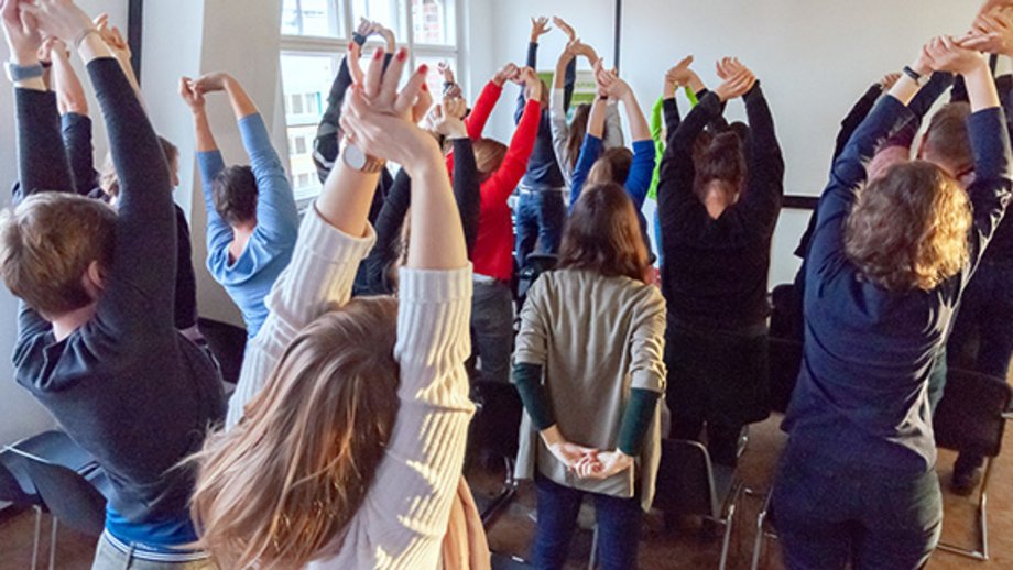 Many people in one room doing stretching exercises