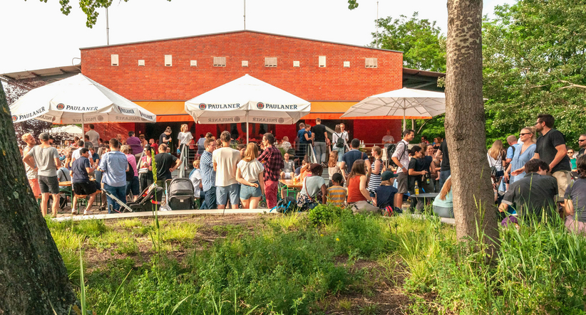 People at a summer party in the park in front of a snack bar