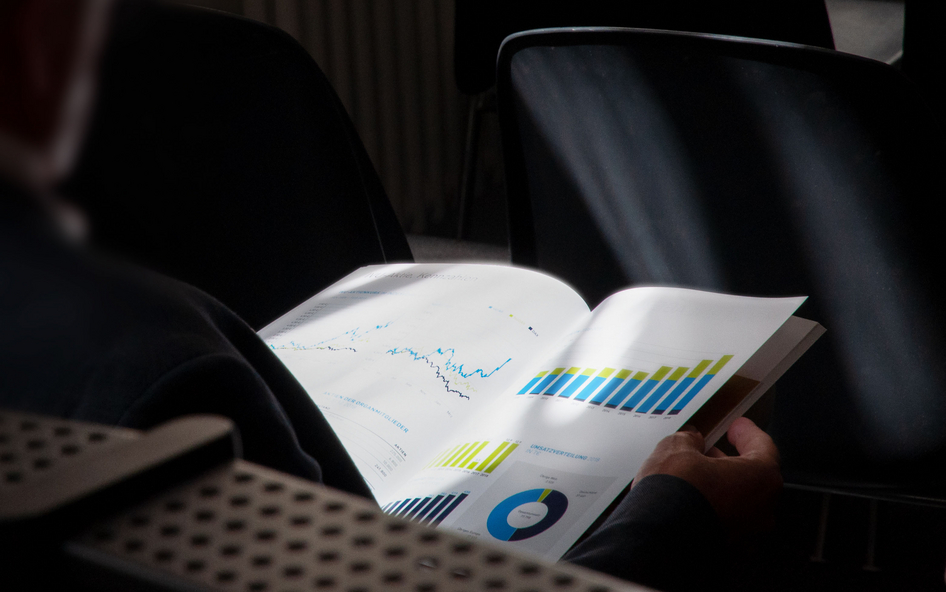 IVU: Record result in the 2020 financial year A person seen from behind, reading an Annual Report