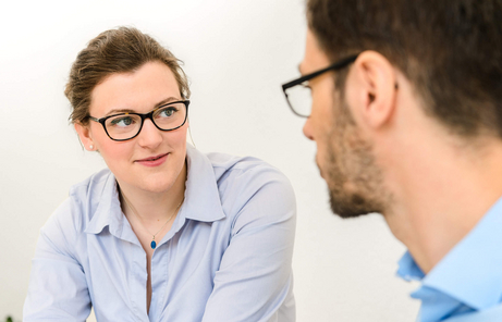 Woman sitting at a table talking with colleagues