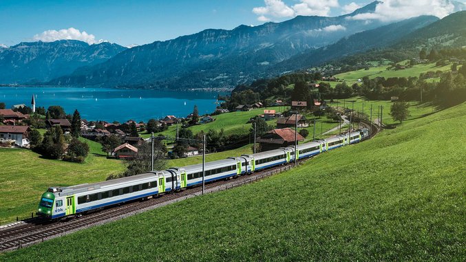 BLS train travelling through the Swiss countryside by the lake