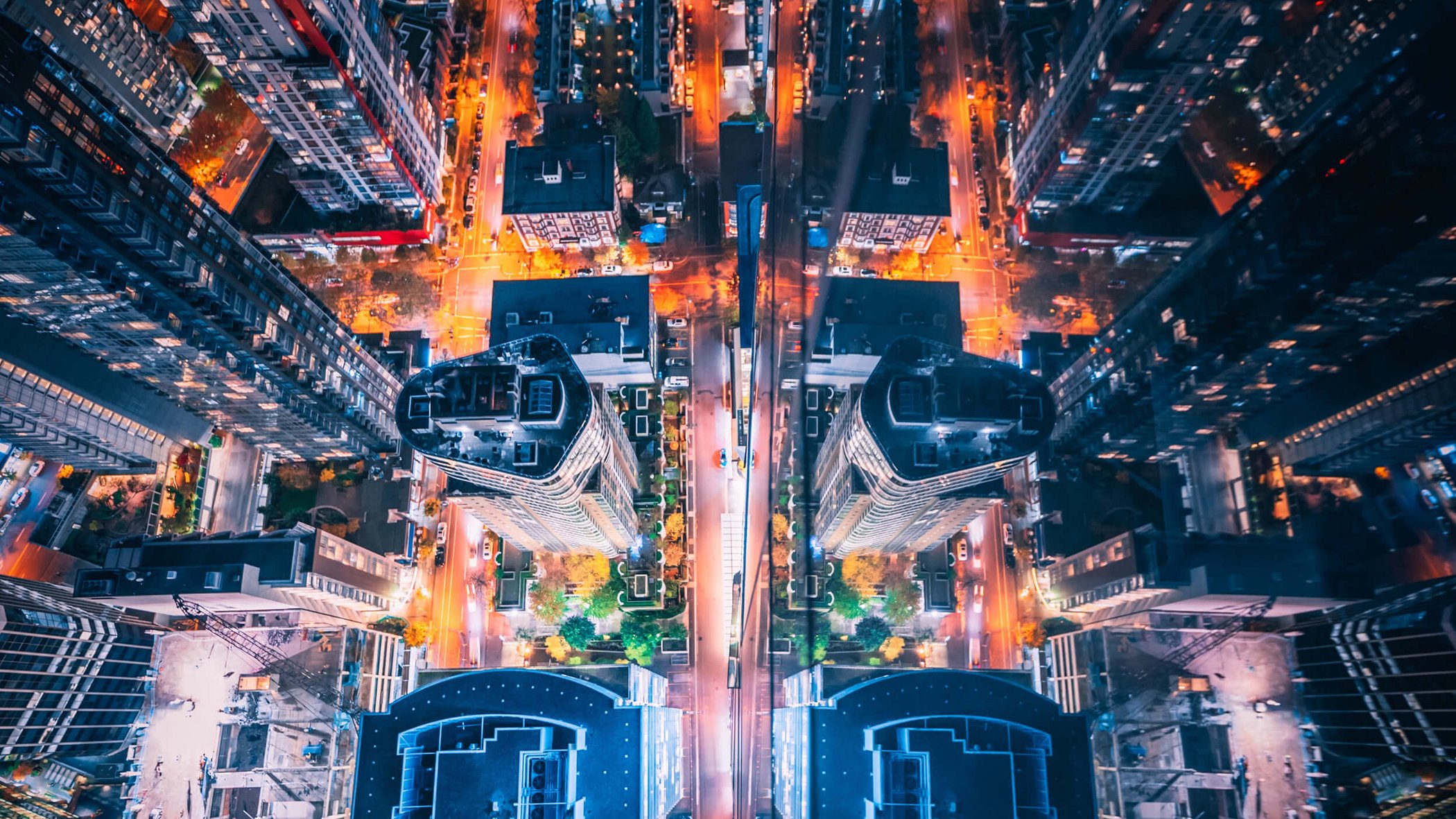 Drone shot of a city at night with illuminated streets and buildings from a bird's eye view