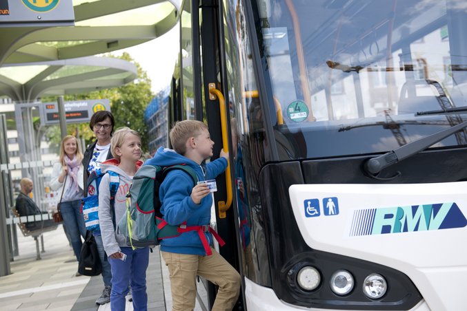 School children board an rms bus at the bus stop