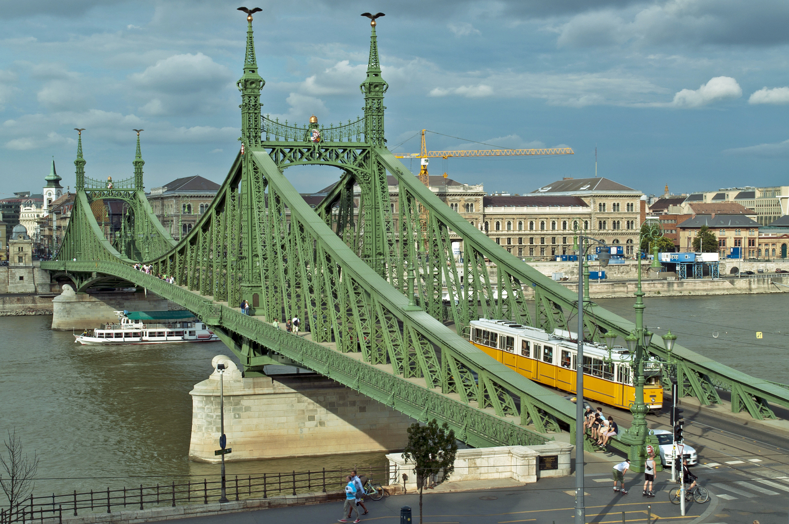 Yellow tram travelling across Liberty Bridge in Budapest