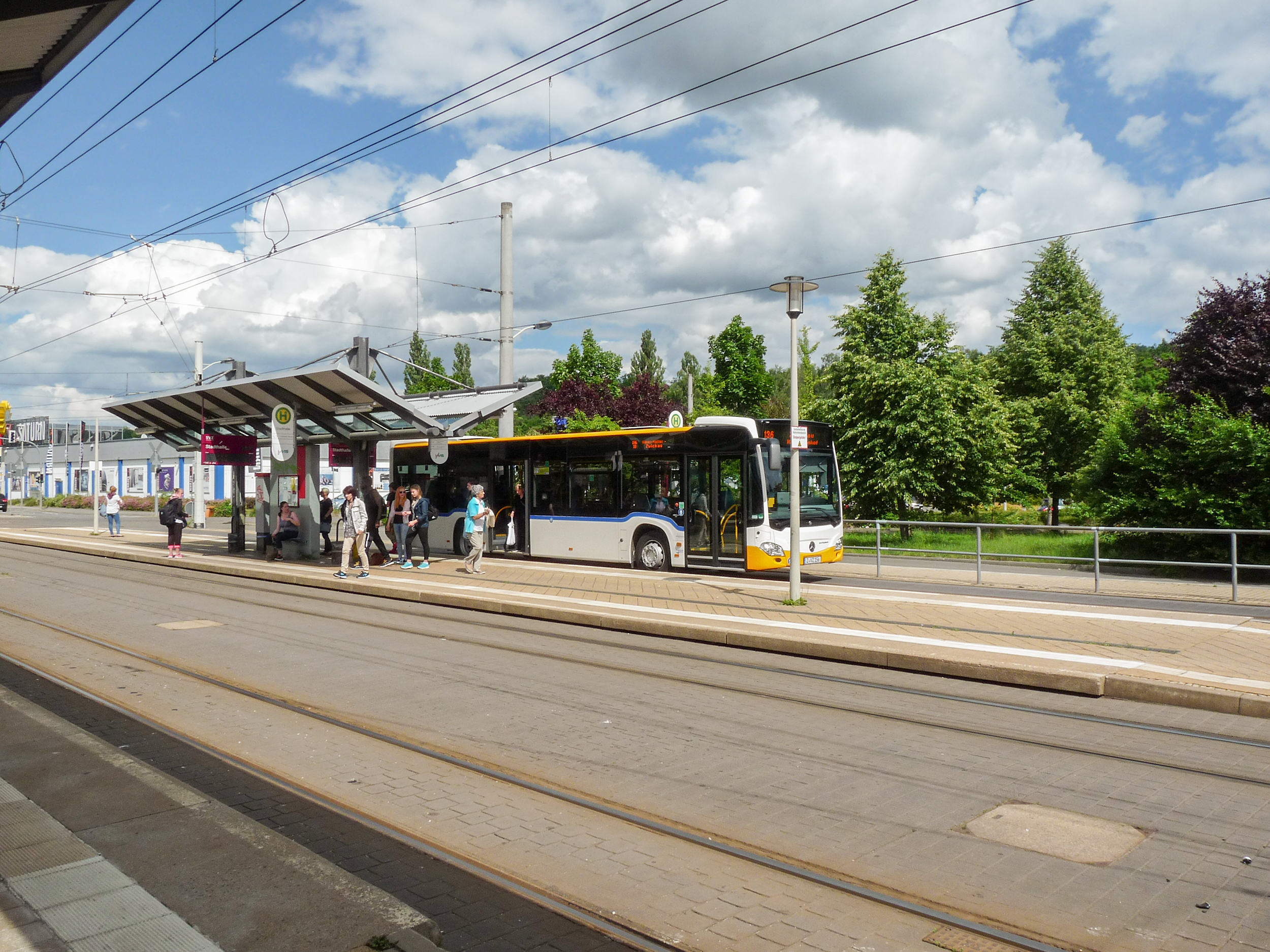 VMS bus at a bus stop with passengers boarding and alighting