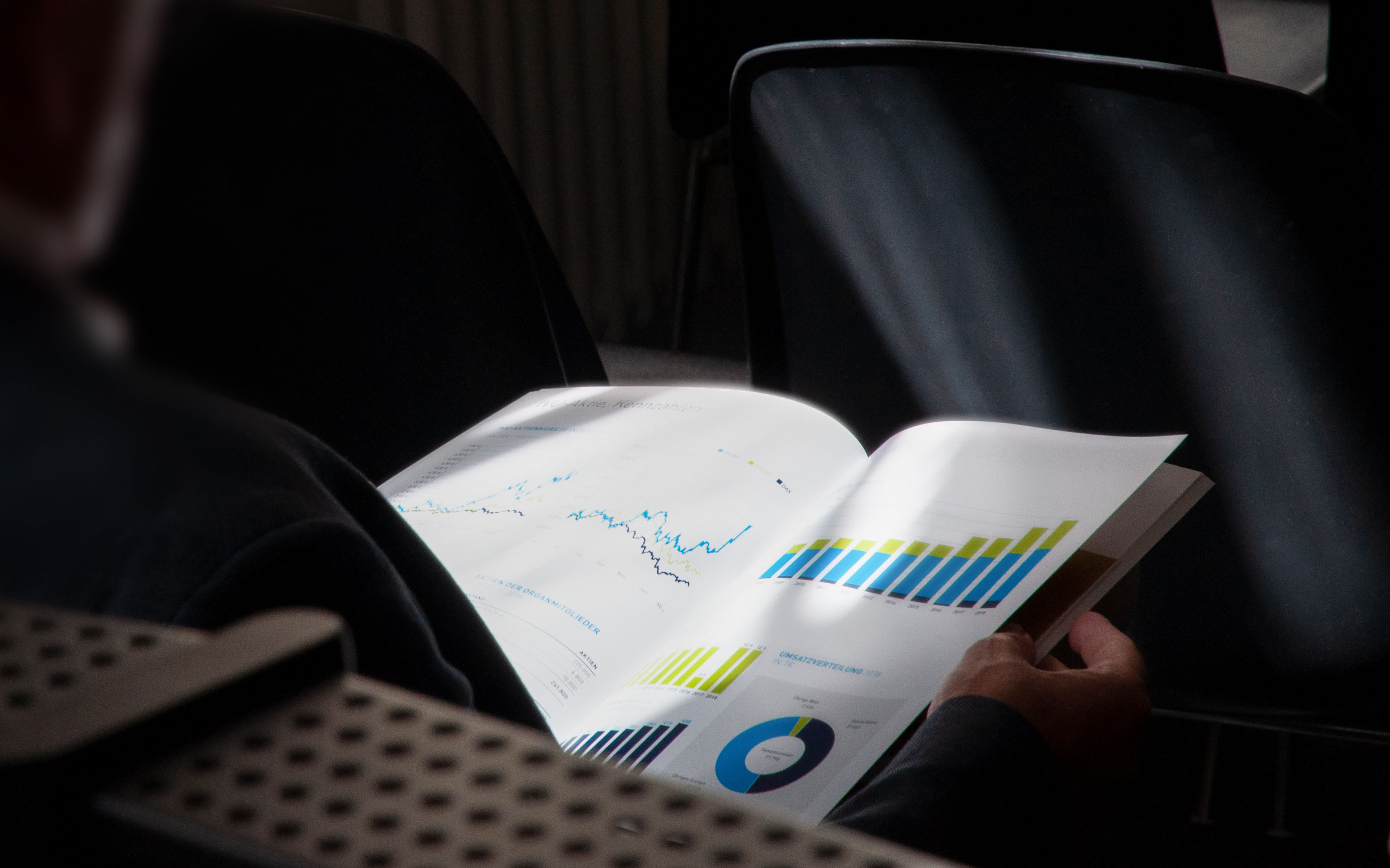 Person holding business report with charts and graphics