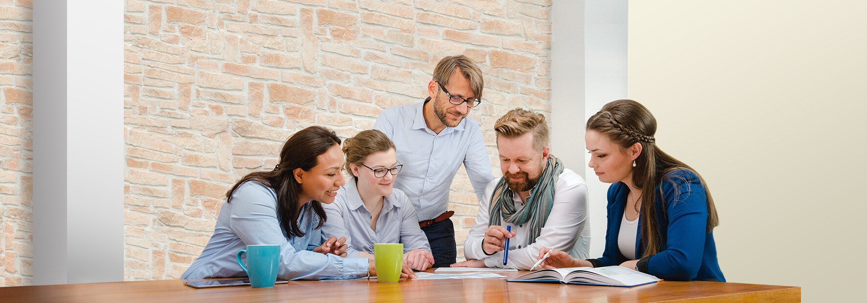 Five colleagues sittting at a table are having a discussion