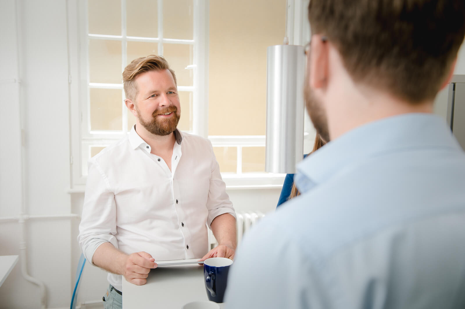 A man seen from the front talking to a man seen from a slightly rear angle